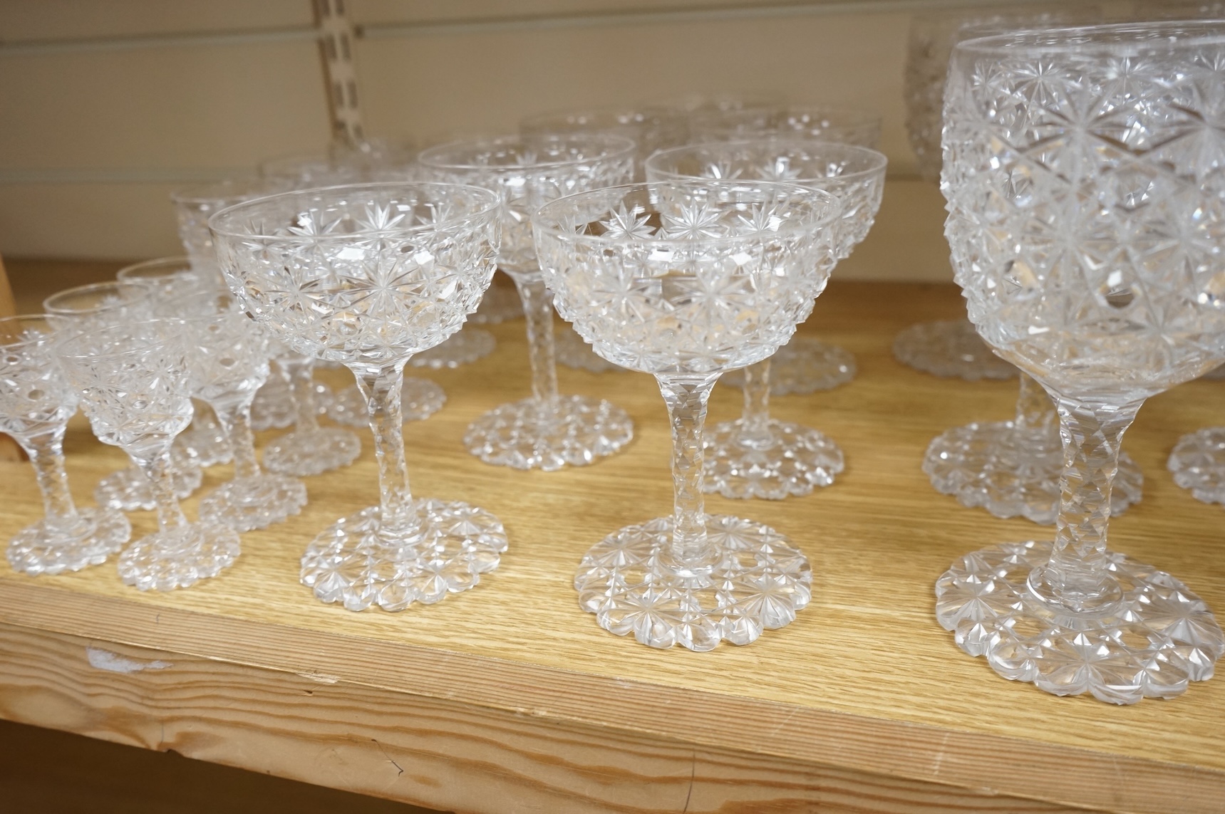 A Victorian heavy hobnail and star cut suite of table glass to include champagnes glasses and two decanters, largest 29cm high